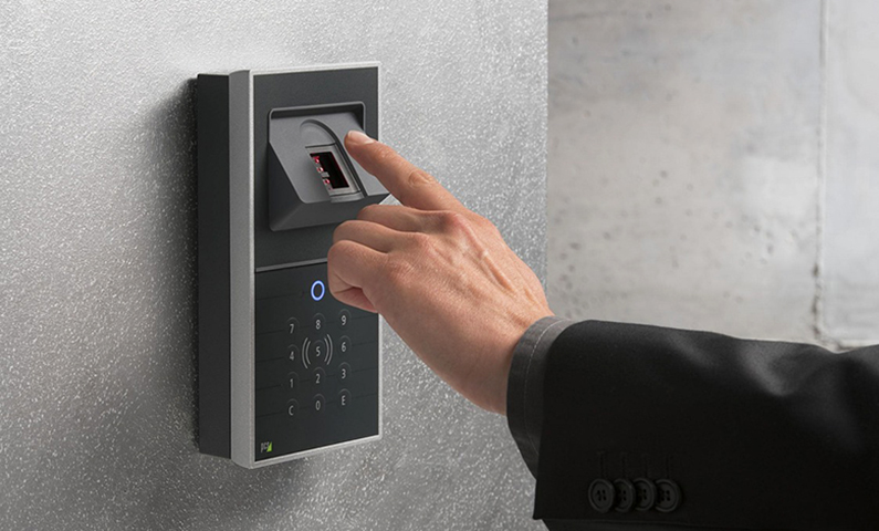 Mano maschile che si avvicina con l'indice teso ad un lettore di impronte digitali, introduce il tema del futuro del controllo accessi.